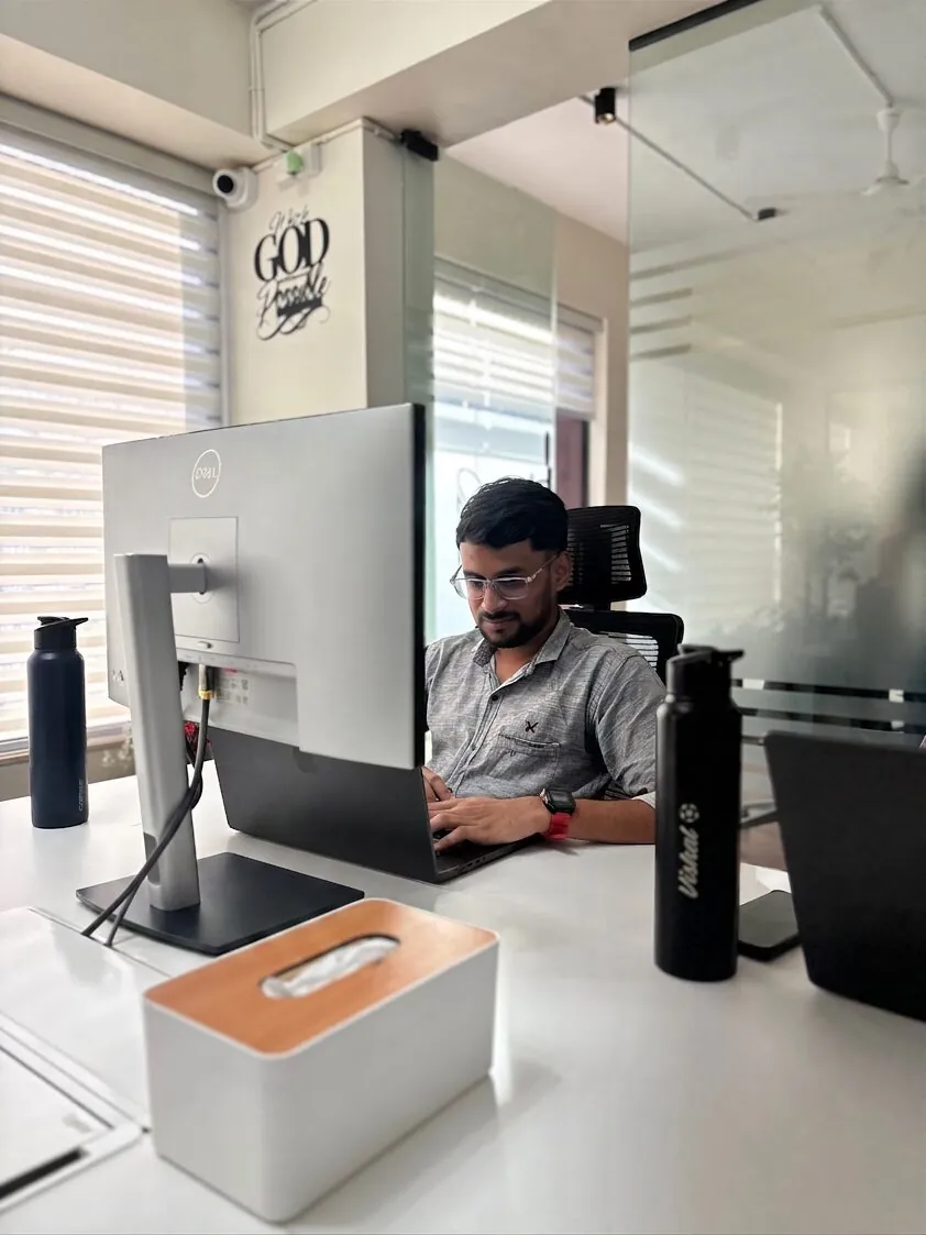 An India Satcom engineer focused at their desk in the office